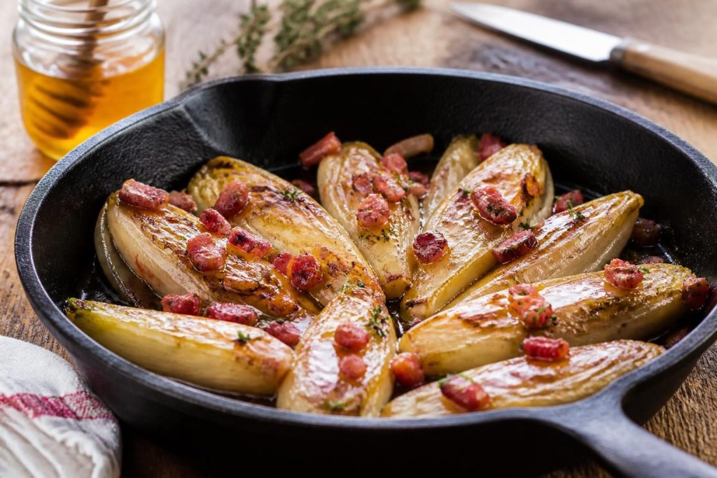 découvrez une recette rapide et savoureuse d'endives braisées à la poêle, délicatement caramélisées au miel et accompagnées de lardons croustillants, idéale pour un repas gourmand et facile.
